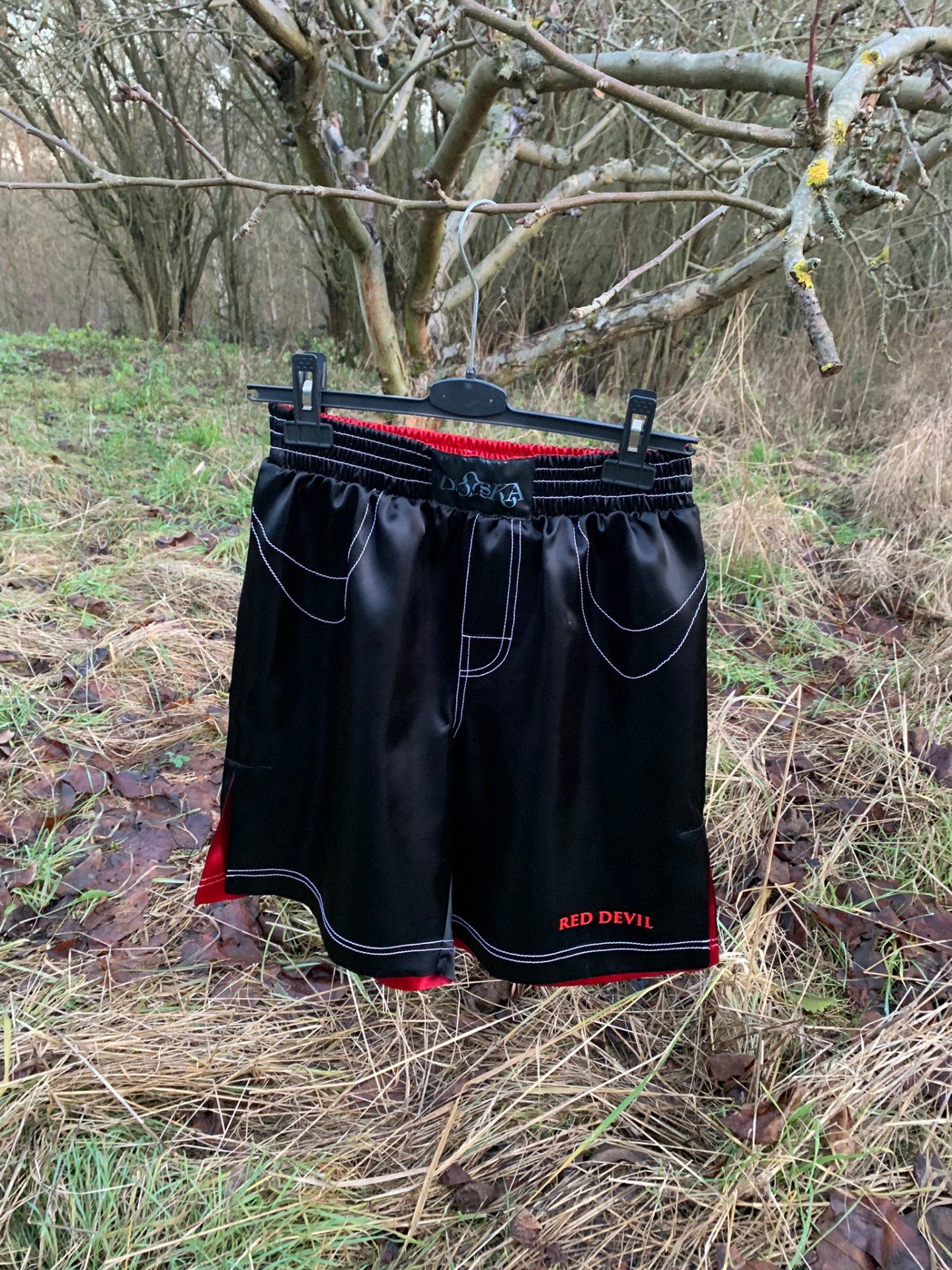 Black Red Devil shorts hanging in woodland